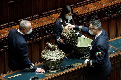 Tres ujieres de la Cámara de diputados italiana revisan las urnas donde se votó ayer al presidente de la República