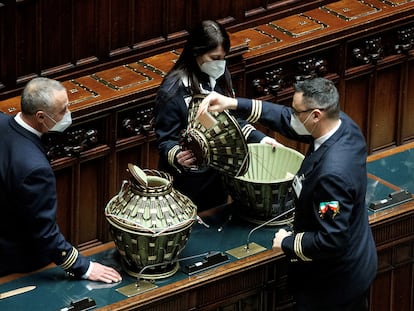 Tres ujieres de la Cámara de diputados italiana revisan las urnas donde se votó ayer al presidente de la República