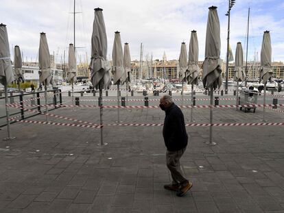 Un hombre pasa delante de una terraza cerrada en Marsella, Francia.