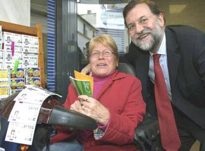 El líder del PP, Mariano Rajoy, junto a una vendedora de la ONCE durante su recorrido por la calle Larga de El Puerto de Santa María.