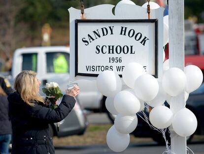 Andrea Jaeger lleva flores y una vela en el exterior de la escuela Sandy Hook, en Newtown.