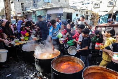 Un grupo de palestinos reciben alimentos en Rafah, al sur de la Franja.