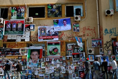 Varias personas observan el muro de Bengasi donde se cuelgan retratos de desaparecidos.
