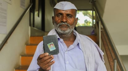 Raju Aage, de 55 años, enseña la fotografía de su hijo asesinado.