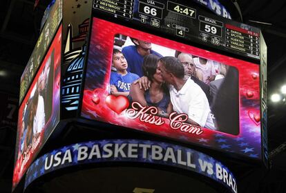 El beso de los Obama queda reflejado en la gran pantalla del estadio donde se anotan los tantos del partido.