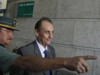 Un agente señala a Lopera el camino para acceder a los juzgados en una imagen de archivo.