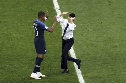 Una mujer que ha invadido el campo choca las manos del francés Kylian Mbappé durante la final.