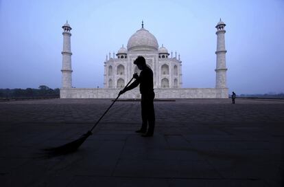 Un hombre barre, por la mañana temprano, ante el monumento del Taj Mahal en Agra, India, el lunes 21 de septiembre de 2020. El Taj Mahal reabrió el lunes después de estar cerrado durante más de seis meses debido a la pandemia de coronavirus.