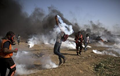 Un manifestante palestino lanza un cartucho de gas lacrimógeo contra las fuerzas israelíes durante una protesta en la Franja de Gaza.