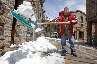 Un hombre saca nieve de la puerta de su casa en Casteller de N'Hug en la comarca de Berguedà, Barcelona.