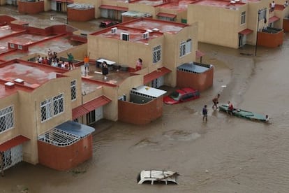 Una familia espera ayuda en el techo de una vivienda en Acapulco.