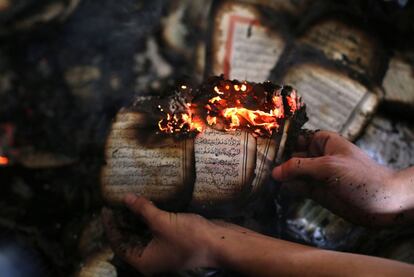 Un palestino muestra una copia quemada del Corán tras un ataque a una mezquita en Cisjordania.