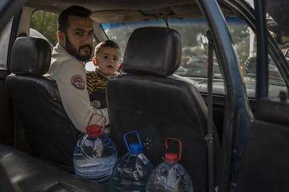 Chadli Mahsan con su hijo en el coche tras rellenar tres garrafas de agua en una fuente pública en el municipio de Byblos, al norte de Beirut. Mhsan llegó al Líbano huyendo de la guerra en Siria. En total hay 1,5 millones de personas refugiadas que tienen muchas más dificultades para acceder al agua y a otros servicios básicos debido a que se encuentran en una situación de mayor vulnerabilidad.