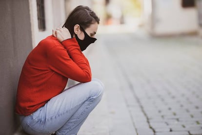 Una mujer se sienta agotada en la calle.