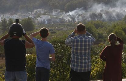 Vecinos observan la evolución del incendio forestal en la zona de Villes del Vent, Benitatxell, una de las zonas donde anoche se desalojaron algunas casas.