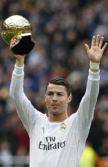 Cristiano ofrece al Bernabéu el trofeo ganado el pasado año.