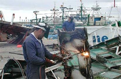 Trabajadores desguazando un pesquero, ayer en Barbate.