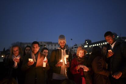 Un grupo de gente sostiene velas durante la vigilia en Trafalgar Square, de Londres.