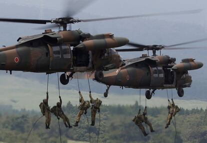 Miembros de las fuerzas especiales japonesas descienden haciendo rápel desde un helicóptero UH-60 Black Hawk durante un entrenamiento militar anual realizado cerca del monte Fuji en el campo de maniobras de Higashifuji, en Gotemba (Japón).