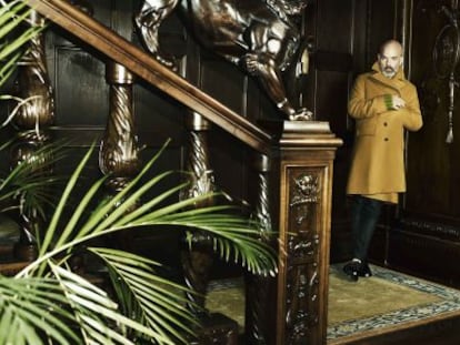 Michael Stipe viste abrigo camel, jersey lima de punto grueso, pantalones y zapatos de charol de Gucci.