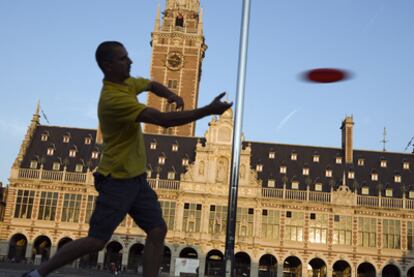 Un hombre juega al <i>frisbee</i> ante la Biblioteca de la Universidad de Lovaina