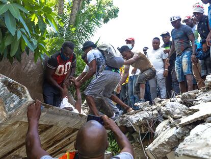 Haitianos se mobilizam para tentar encontrar sobreviventes sob os escombros, em Los Cayos, Haití.