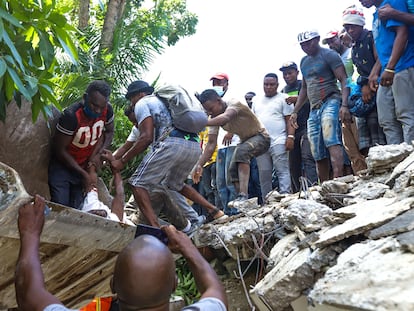 Haitianos se mobilizam para tentar encontrar sobreviventes sob os escombros, em Los Cayos, Haití.