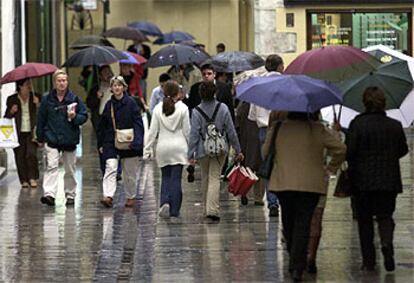 Un grupo de personas camina bajo la lluvia por el centro de Málaga.