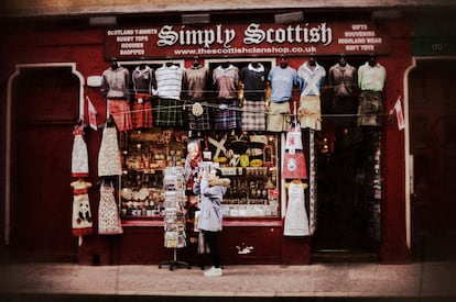 Una mujer junto a una tienda de recuerdos en el centro de la capital escocesa.