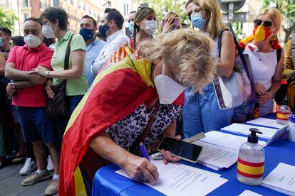 Una mujer firma contra los indultos en la manifestación de la plaza de Colón de Madrid el pasado domingo.