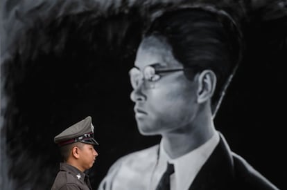 Un policía tailandés frente a un retrato del difunto rey Bhumibol Adulyadej. Unos 58.000 policías velarán por la seguridad de la ceremonia funerario, que implicará, entre otras medidas, cortes de las calles cercanas al Gran Palacio Real.