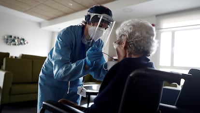 Una cuidadora ayuda a comer a una anciana en una residencia del barrio madrileño de Villaverde, en Madrid, en pasado abril.