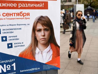 Una mujer pasa, en Moscú, junto al cartel de una candidata de la oposición rusa,
