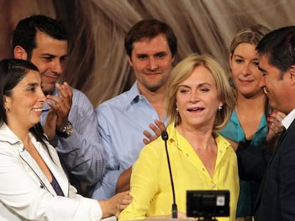 Evelyn Matthei, de amarelo, é reconfortada após reconhecer a derrota.