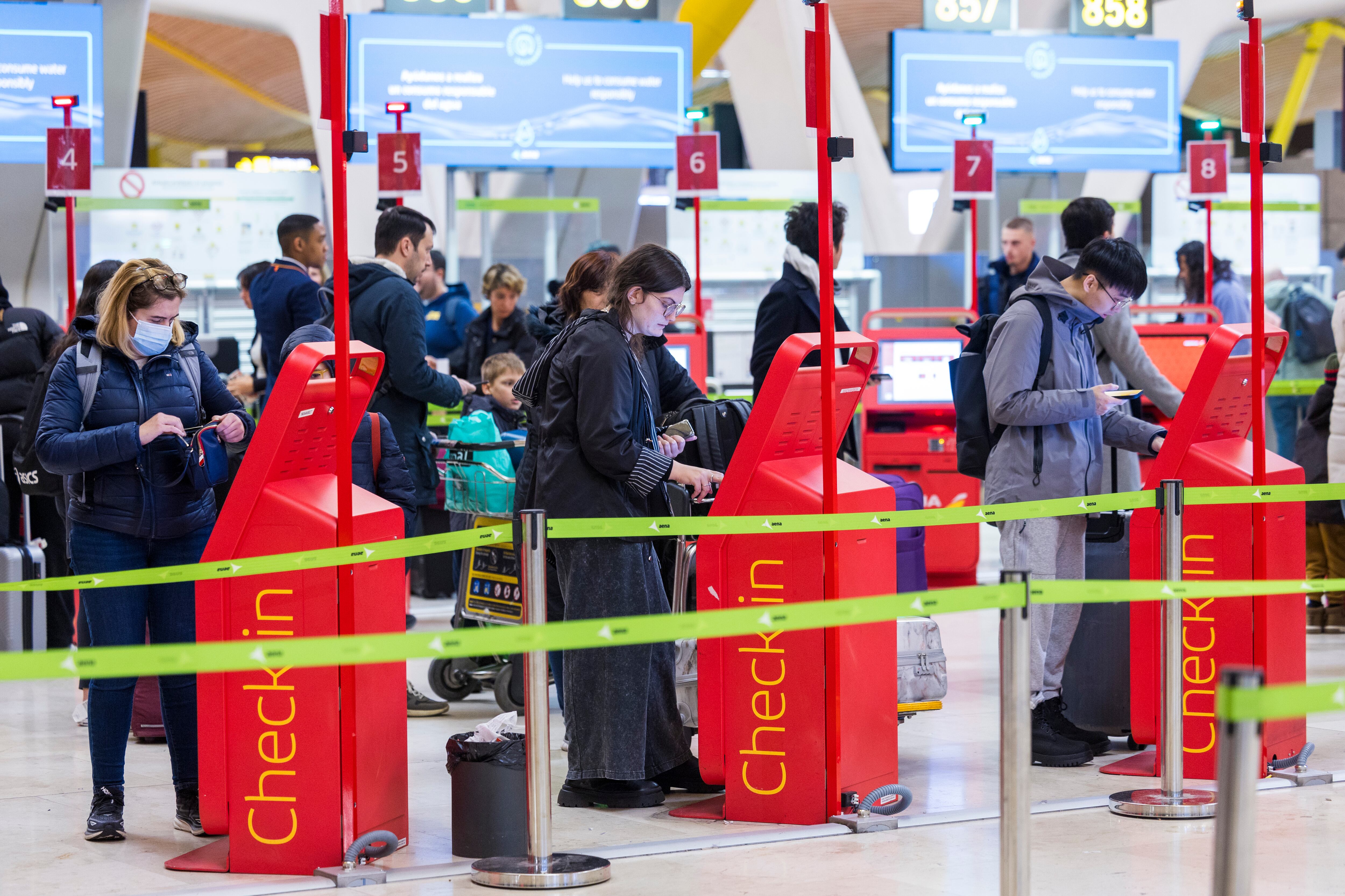 Viajeros de Iberia, este viernes en el aeropuerto de Madrid. 