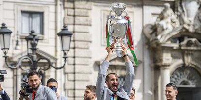 Los jugadores de la selección italiana levantan el trofeo a su llegada a Roma.