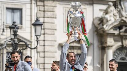 Los jugadores de la selección italiana levantan el trofeo a su llegada a Roma.