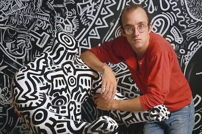 El artista Keith Haring al lado de una de sus creaciones en 1986.