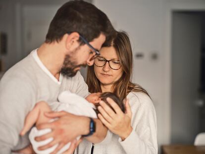 Un padre y una madre sostienen a su bebé.