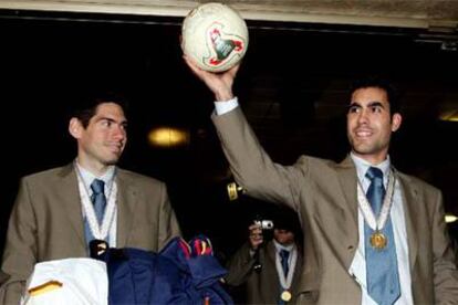 Kike y Andreu levantan en el aeropuerto de Barajas el balón con el que ganaron el Campeonato del Mundo.
