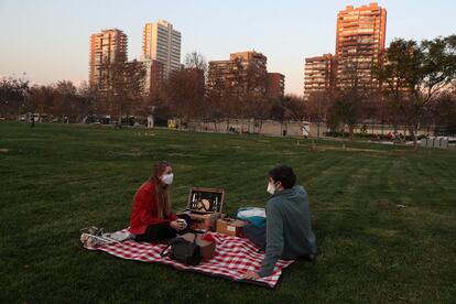 Una pareja disfruta de un picnic en un parque de Santiago (Chile). El país suramericano ha experimentado una reducción de los contagios de coronavirus en ocho regiones, incluida la Metropolitana, donde se encuentra Santiago, en un momento en el que el balance de la pandemia roza los 350.000 casos.