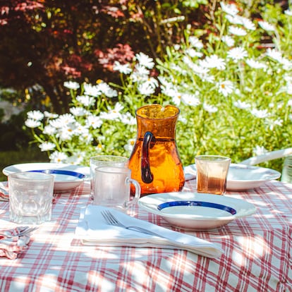 Cozy outdoor dining setting awaits, with a mature adult enjoying a book in the tranquil garden background