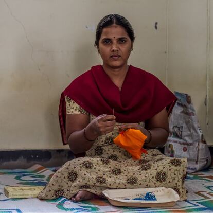 Lakshmidevi tiene un 78% de discapacidad por culpa de la polio, que le paralizó una pierna cuando tenía cuatro meses, pero puede caminar gracias a una prótesis. También tiene un triciclo enorme que maneja con gran soltura: con una mano lleva el volante y con la otra da vueltas a una manivela que mueve las ruedas. Pero ahora no necesita nada de eso, ella prefiere gatear por la habitación en la que otras 20 chicas con discapacidades similares se afanan en bordar cojines, colchas y artículos para el hogar. A los 10 años, Lakshmidevi fue examinada por médicos de la Fundación Vicente Ferrer, que decidieron someterla a una cirugía que corrigió la malformación de su pie. Luego se lo escayolaron hasta en cinco ocasiones. “Me quitaban los yesos cada dos meses y me los volvían a poner para que los huesos quedaran bien fijados”, describe. Entre visitas al médico y sesiones de rehabilitación, Lakshmidevi estudió hasta décimo curso. En su casa siempre se ha sentido muy arropada, tanto por sus padres como por sus hermanas y, de hecho, vive con ellos y no en los talleres, como sí hacen otras 110 chicas. En casa trabaja bordando y sale para recoger material, dejar productos ya terminados o echar una mano cuando llega un encargo muy grande. En cuanto a su futuro, tiene claro que se quiere casar. “Mis padres están buscando candidato, pero tienen que pensar mucho cómo negociar mi dote porque debido a mi discapacidad van a tener que pagar más por mí”, dice la joven sin inmutarse.