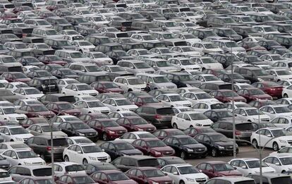 Una persona camina rodeada de cientos de vehículos, fabricados por General Motors, aparcados en una explanada en Shenyang, provincia de Liaoning, China.