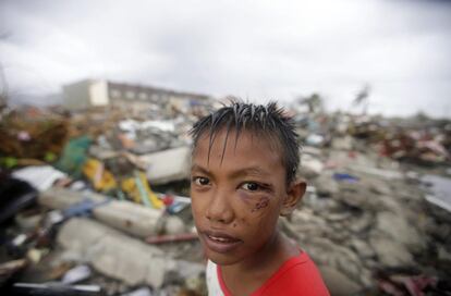 Un niño filipino aguanta delante de su casa el paso del tifón.