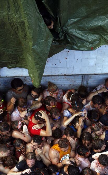 Un veí contempla des del balcó de casa la Tomatina al carrer principal de la localitat valenciana de Bunyol, el 26 d'agost del 2015.