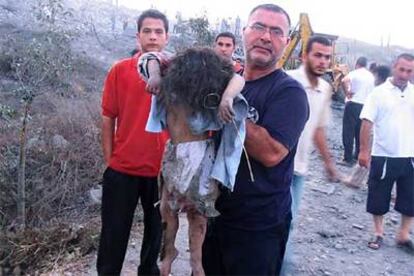 Civiles libaneses muestran a una niña muerta durante un bombardeo israelí sobre la localidad de Dweir.