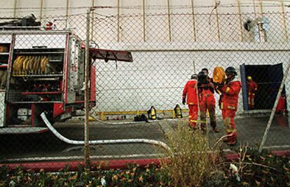 Los bomberos, durante la extinción, en la nave de la fábrica del parque Juan Carlos I de Almussafes, donde se registró el incendio.