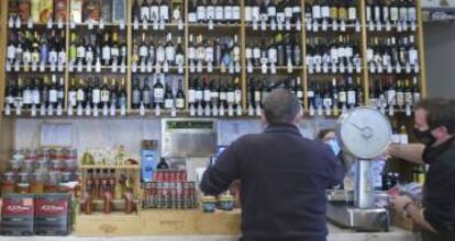 Interior del comercio en el que los dependientes atienden a un cliente.