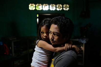 Un hombre sujeta a su hija en el interior de su casa durante las protestas en León (Nicaragua), el 5 de julio de 2018.